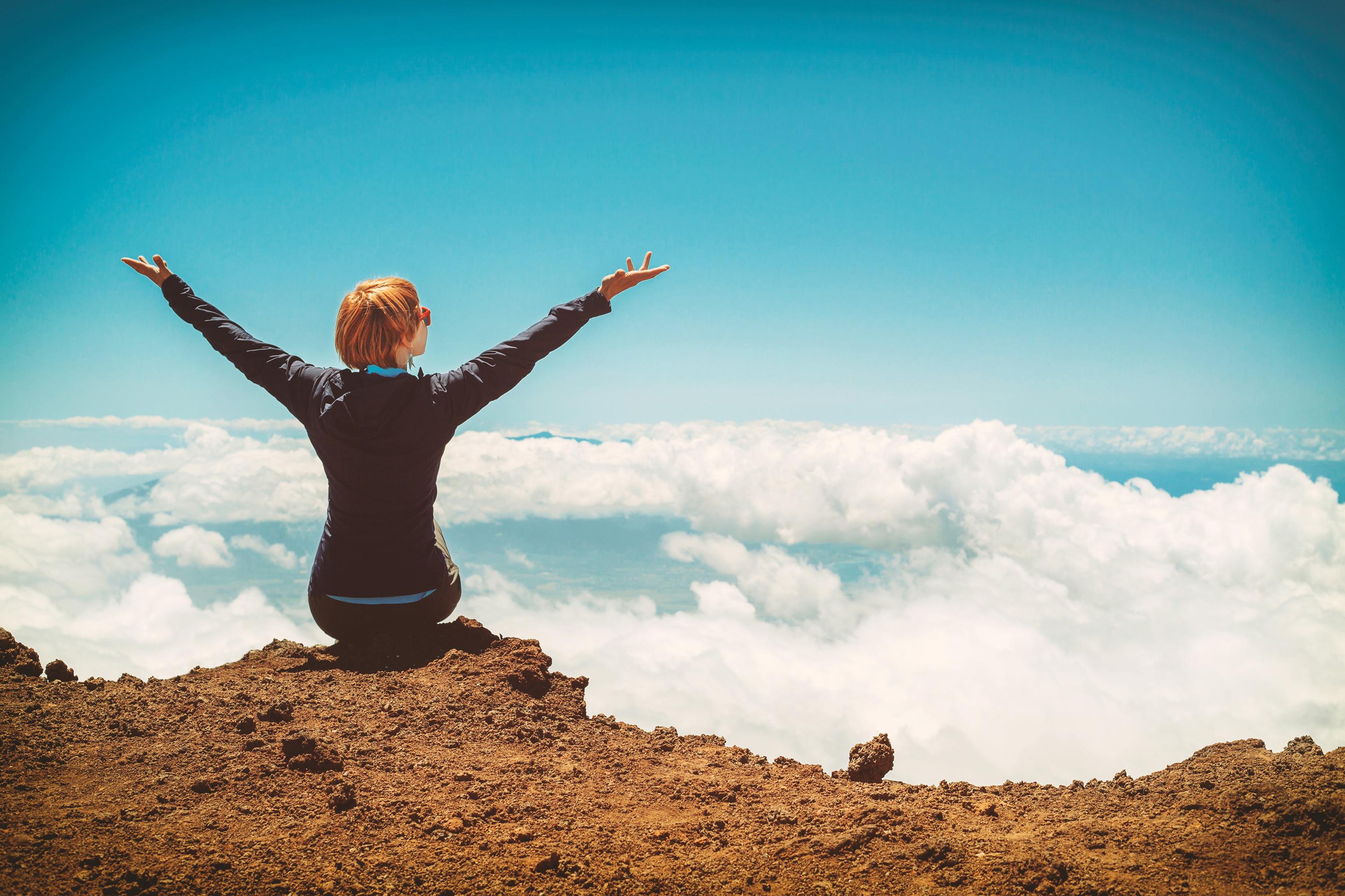 Woman with arms raised on mountain